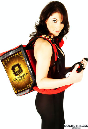 Vista lateral de una mochila dispensadora de café profesional que incluye compartimentos laterales para vasos desechables, azúcar y removedores, optimizando el servicio de venta ambulante.